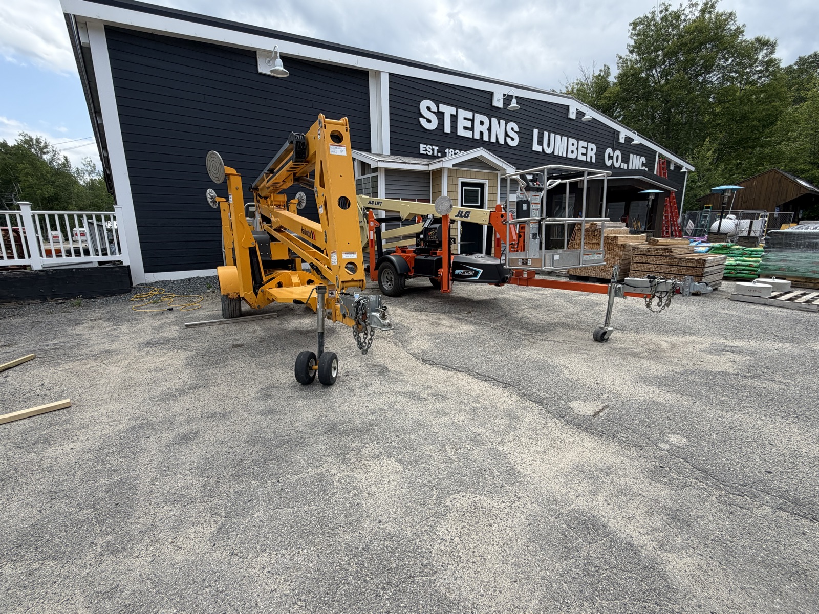 Towable boom lifts parked in front of the Sterns Lumber store
