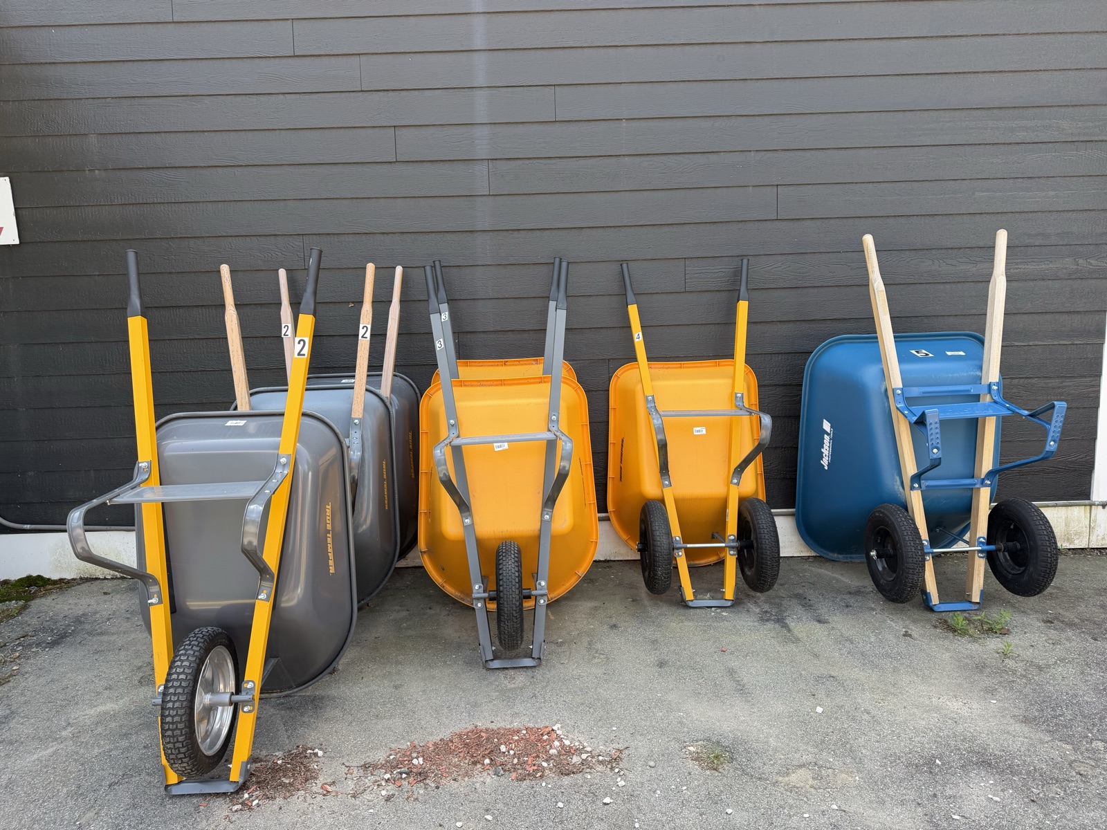 Wheelbarrow display lined up against the store siding